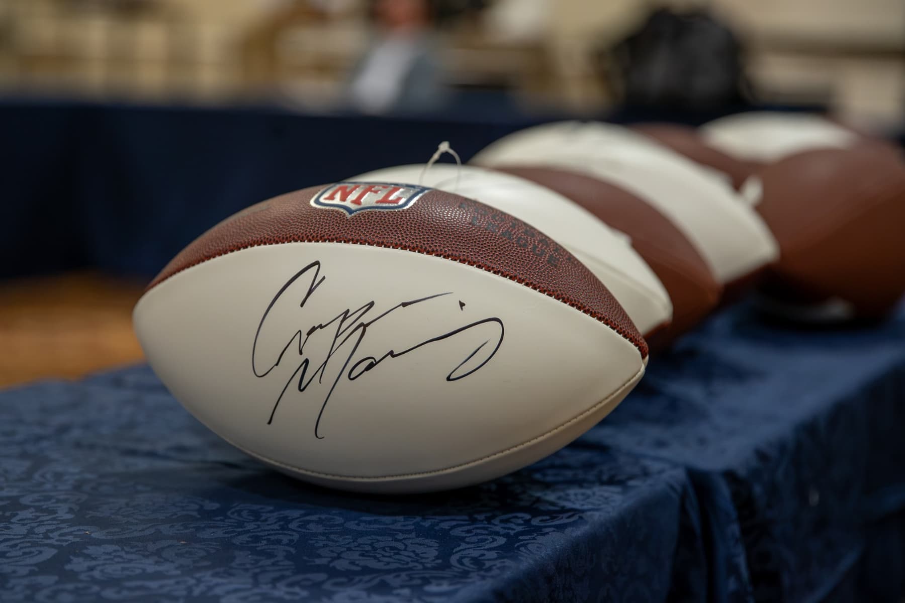 NFL footballs signed by Cooper Manning on a table