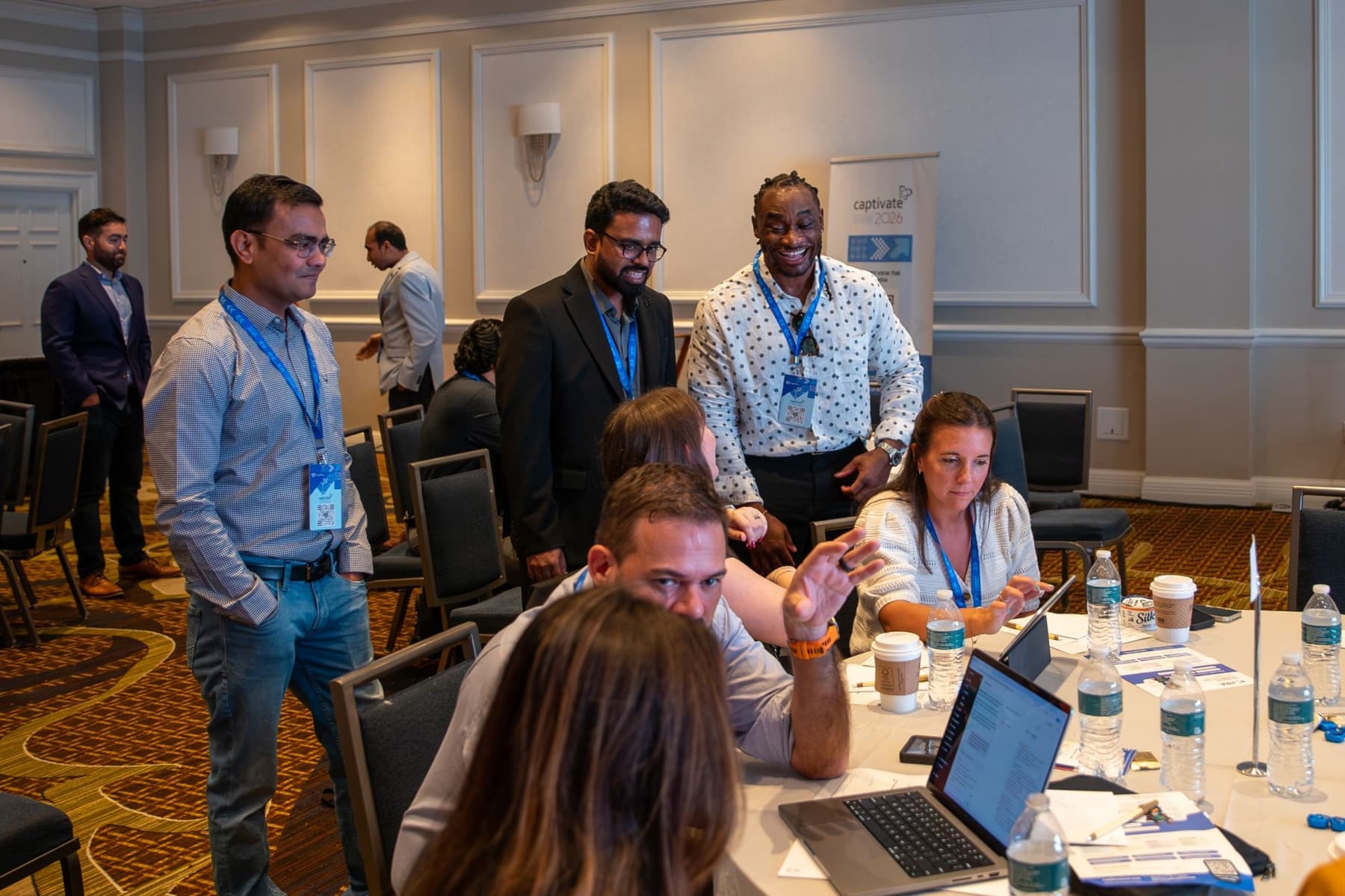 Attendees gathered around a laptop during a working session
